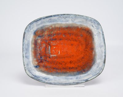 assiette orange et bleue avec un fond blanc, posée sur une surface blanche