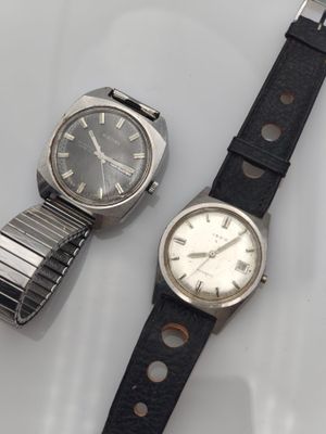 une photo montrant deux montres posées sur une surface blanche
