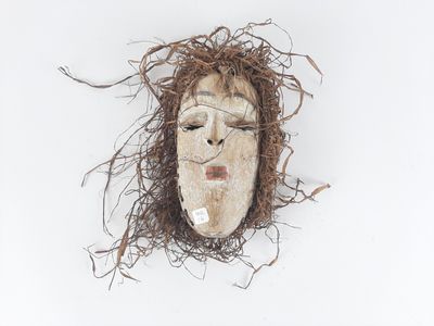 a white mask with brown hair on a white surface