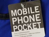 the back of a cell phone pocket with a tag attached to it