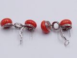 pair of red coral and silver earrings on a white background
