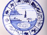 a blue and white plate with a picture of a lighthouse