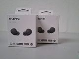 two boxes of sony earphones sitting on top of a white table
