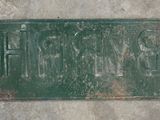 a green sign on the side of a cement wall