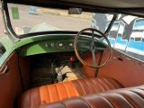 an old car with a steering wheel and leather seats