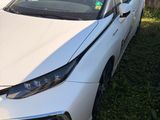 the front of a white toyota mira parked next to a white van
