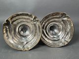 pair of silver plated ashtrays on grey background