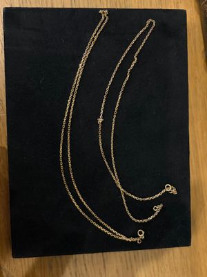 a black box with three necklaces on it sitting on a table