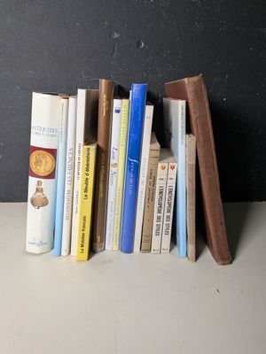 une pile de livres posée sur une étagère près d'un mur noir