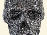 a black and silver skull statue on a white background