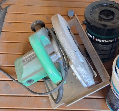 quelques outils sont posés sur une table en bois à côté d'un pot de peinture