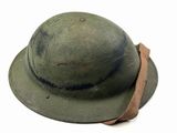 an old army helmet with a leather band on a white background