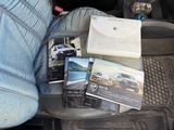 a person sitting in the back seat of a car with a lot of books