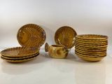 gold plate set with bowls and plates on a white surface