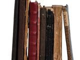 une pile de vieux livres posée sur une surface blanche