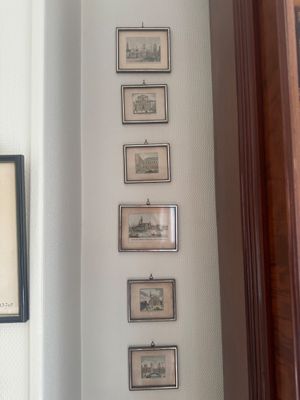 des tableaux accrochés au mur d'un couloir dans une maison