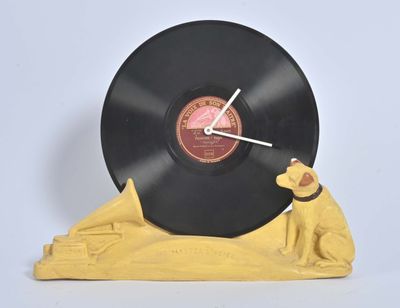 une horloge sur laquelle sont posés un disque vinyle et une figurine de chien