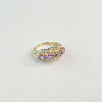 un gros plan d'une bague en or sertie d'améthyste et de diamants