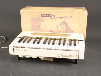 un petit piano blanc avec une boîte posée sur la table