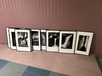 four black and white photographs are arranged on the floor next to a pink wall