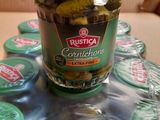 un bocal de cornichons posé sur une table