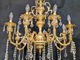 an image of a gold chandelier with crystal drops hanging from it