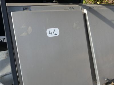 two refrigerators sitting next to each other on the side of the road