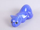 a blue cat figurine sitting on a white surface
