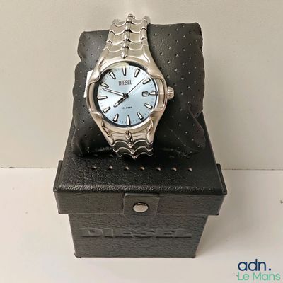 une montre en argent posée sur un coffret noir