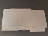 four sheets of white paper sitting on top of a table