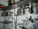 many dishes and pans on the shelves in the kitchen