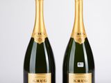 deux bouteilles de champagne posées l'une à côté de l'autre sur une table