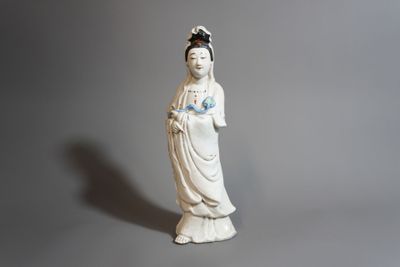 une statue de femme tenant une fleur à la main