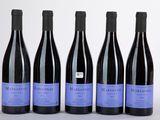 quatre bouteilles de vin sont alignées sur une table