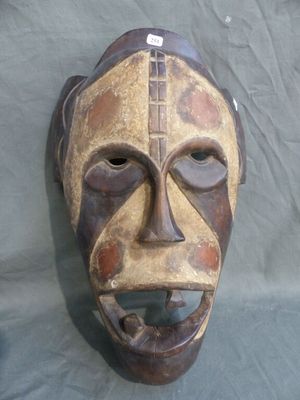 a wooden mask on a table with a blue cloth