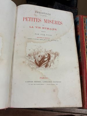 un livre ouvert sur une étagère, à côté d'autres livres