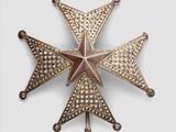 an antique silver and gold star broochle on a white background