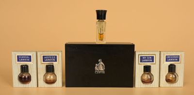 three bottles of perfume sitting on top of a table next to a box