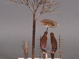 two birds that are sitting on a bench under an umbrella