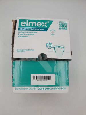 un tube de dentifrice Elmex vide posé sur une table