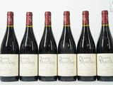 six bouteilles de vin sont alignées sur une surface blanche