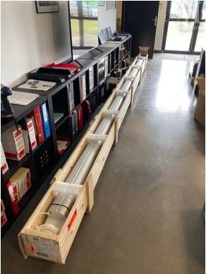 une longue table sur laquelle sont posées plusieurs boîtes