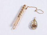 a pen and a pendant on a white surface