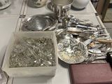 a table with a lot of silverware and silverware on it
