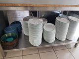 beaucoup d'assiettes et de bols posés sur une étagère en métal