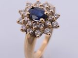 a close up of a gold ring with a blue sapphire and white diamonds