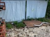 a pile of junk in the yard next to a fence
