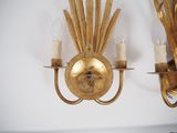two gold sconces on the wall of a room