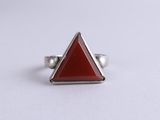 a close up of a triangle shaped ring with a red stone in the middle
