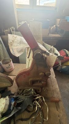 Plusieurs paires de chaussures sont posées sur une table dans une pièce encombrée.